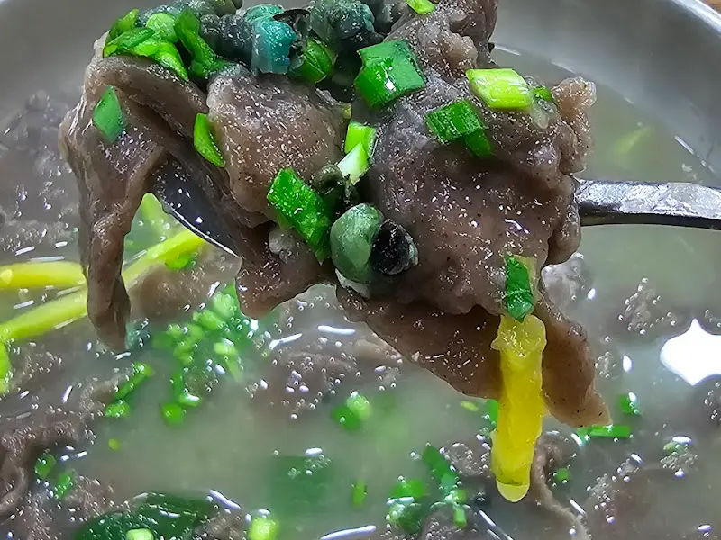 숟가락 위에 올려진 다슬기 메밀 수제비