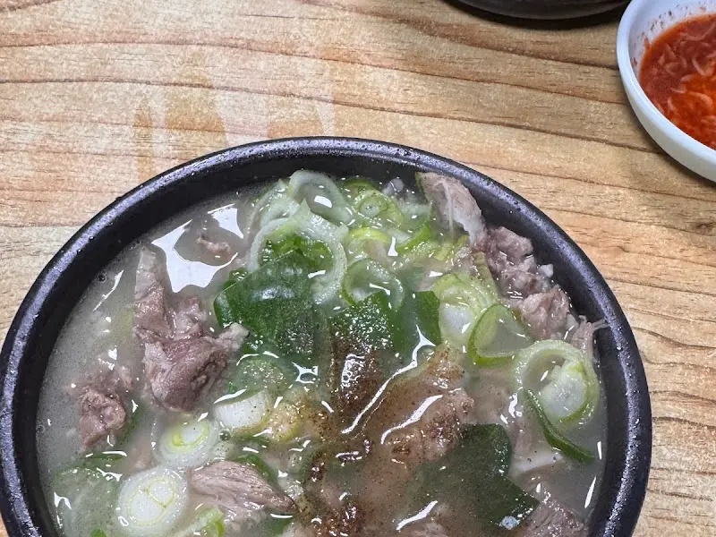 돼지국밥에 깍두기를 올려 먹는 모습