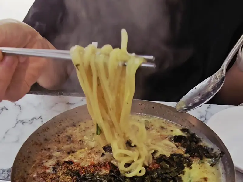 젓가락으로 칼국수 면을 들어올리는 모습