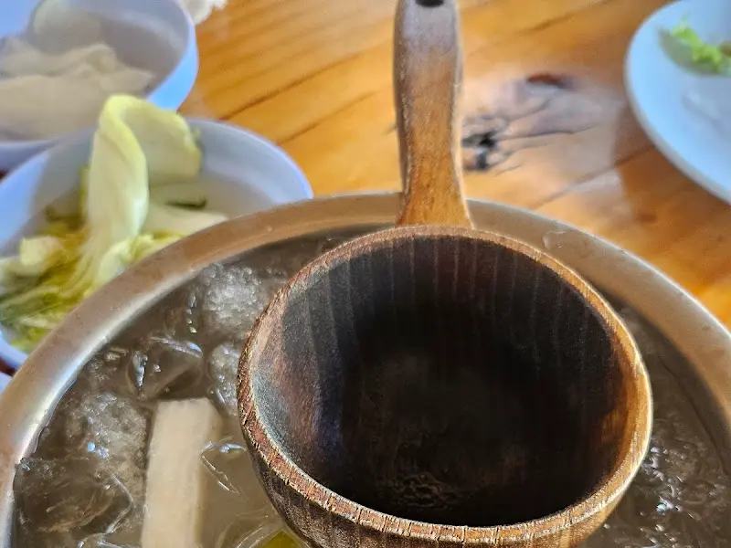 나무 국자로 동치미 국물을 뜨는 모습