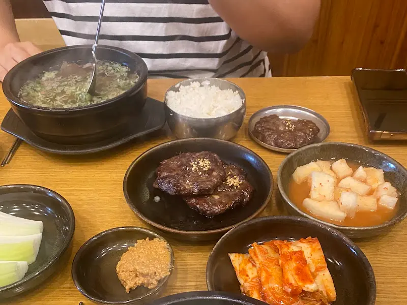 곰탕과 떡갈비, 깍두기, 양파, 고추가 놓인 테이블