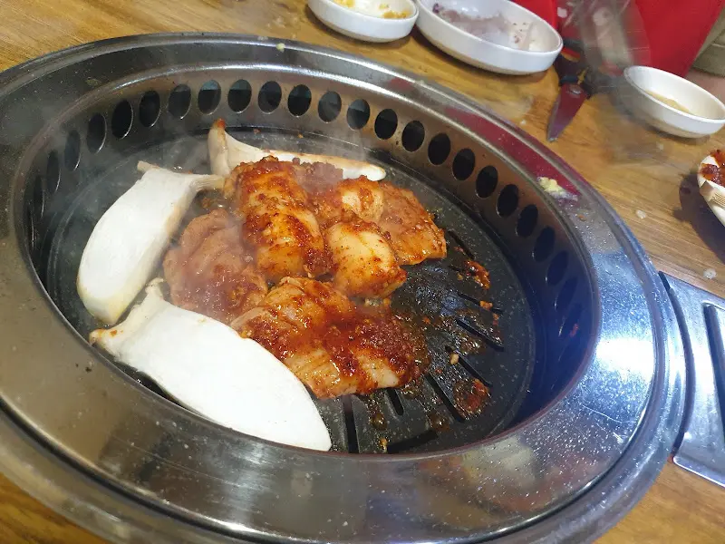 불판 위에 양념과 함께 구워진 OOO과 OOO