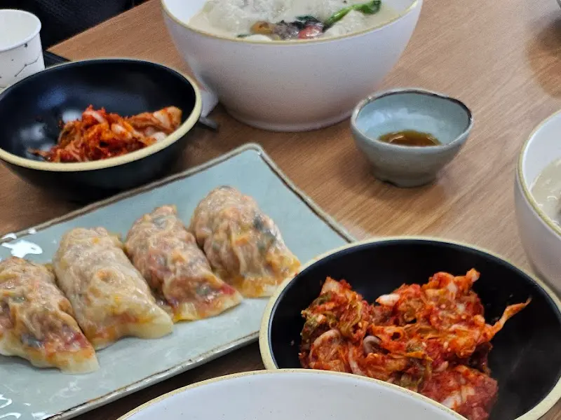 김치, 만두, 칼국수가 함께 담겨있는 푸짐한 한 상 차림