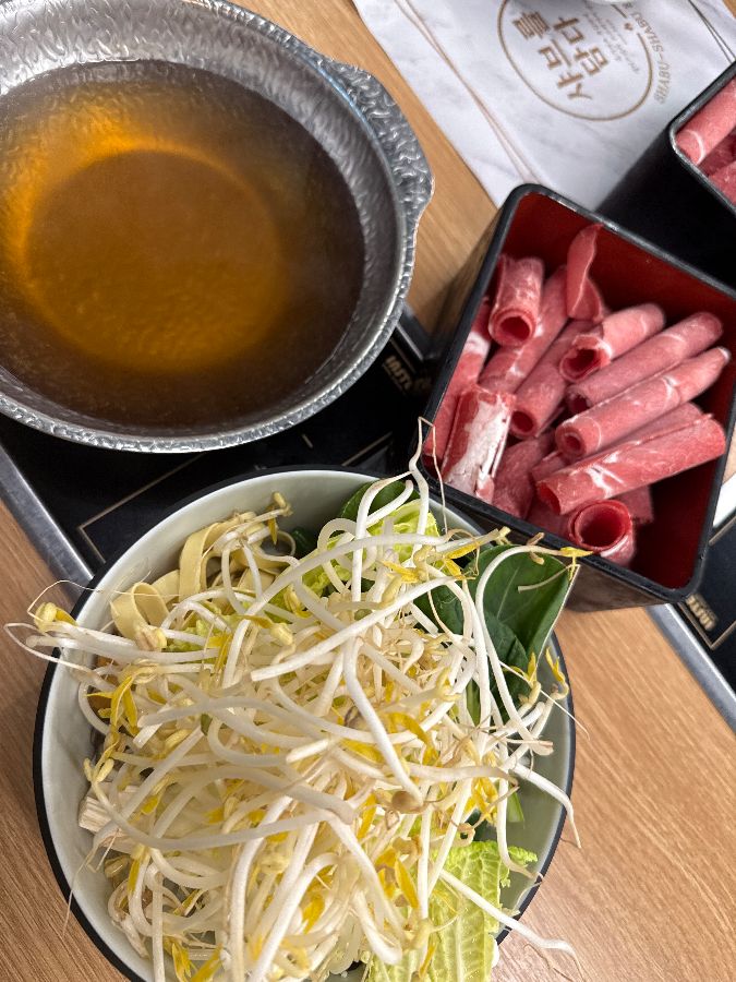 샤브샤브 재료와 육수가 테이블 위에 놓여 있는 모습