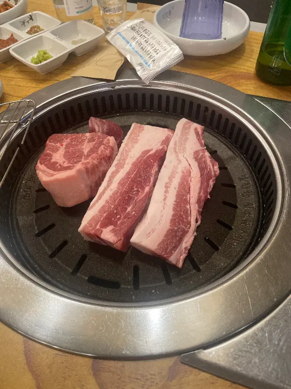 불판 위에 올려진 두툼한 숙성 삼겹살