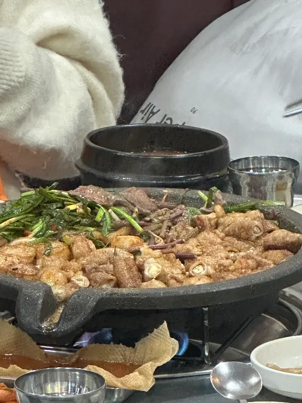 돌판 위에 노릇하게 구워진 곱창과 대파 김치, 그리고 뜨끈한 선지 해장국