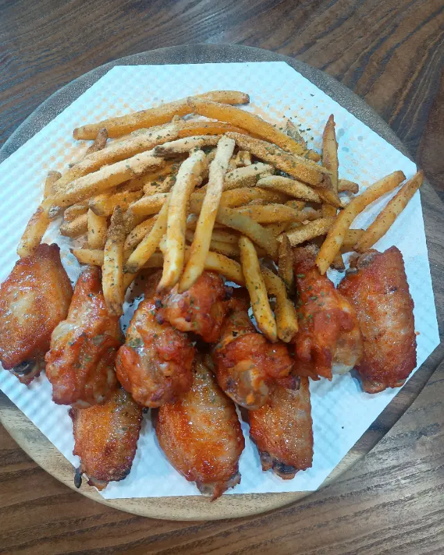 접시에 담긴 치킨 윙과 감자 튀김