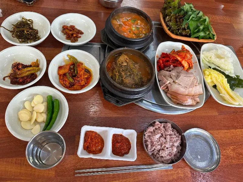 수육쌈밥 정식 한 상 차림. 푸짐한 수육과 다양한 쌈 채소, 밑반찬이 눈길을 사로잡는다.