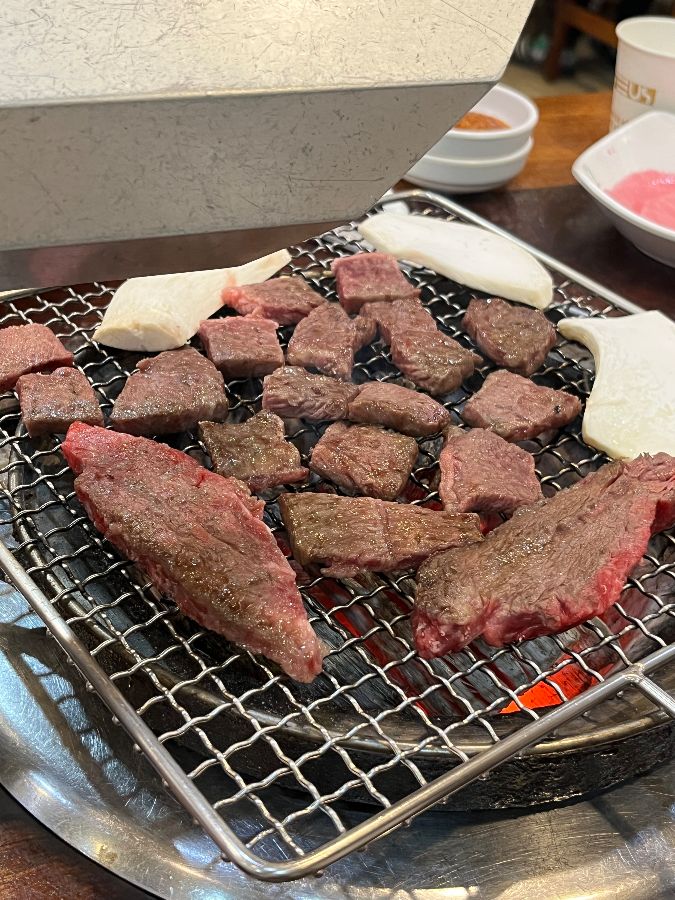 숯불 위에서 익어가는 한우 안심과 버섯