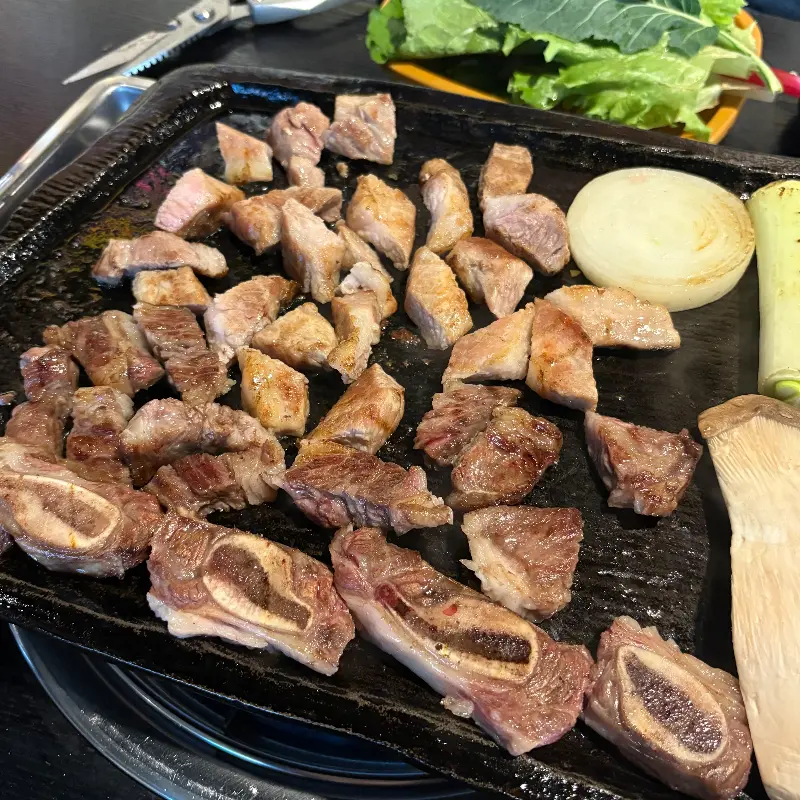 볶음밥 재료와 구운 야채, 잘 익은 고기가 놓여진 불판