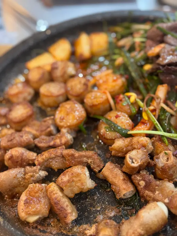 돌판 위에 곱창, 대창, 염통과 부추가 함께 구워지고 있는 모습