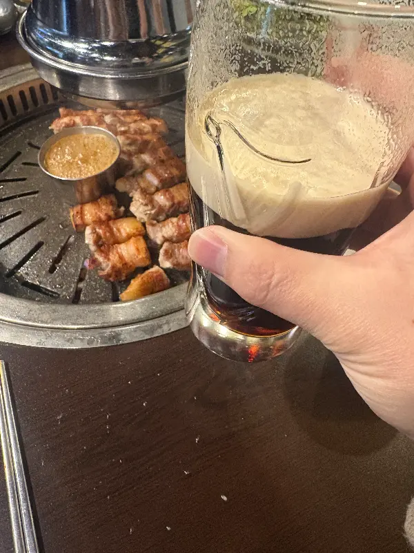 잘 구워진 돼지고기 한 점과 시원한 맥주