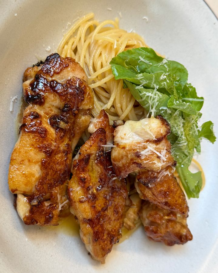 윤기가 흐르는 닭다리살이 식욕을 자극하는 그릴 닭다리 오일 파스타