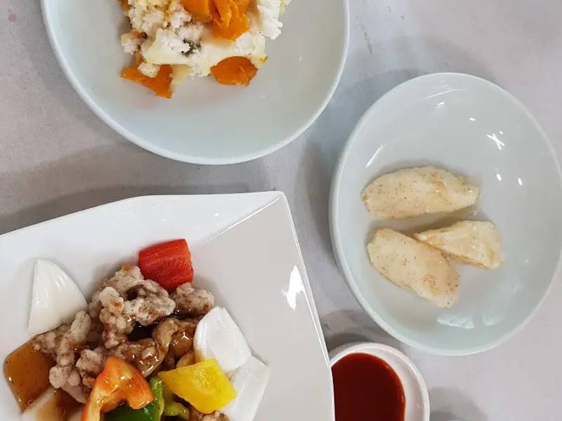 테이블 위에 호박이 섞인 백설기와 탕수육이 놓여 있다.