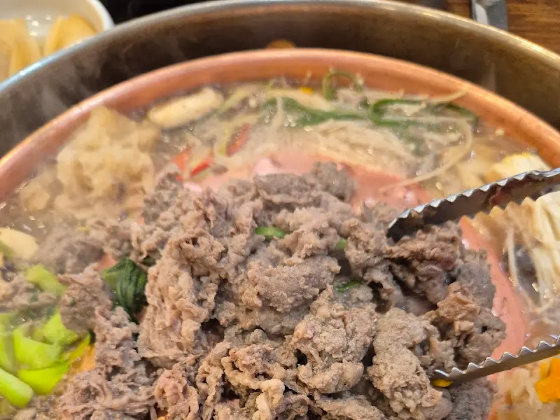 불고기를 집게로 집어 올리는 모습