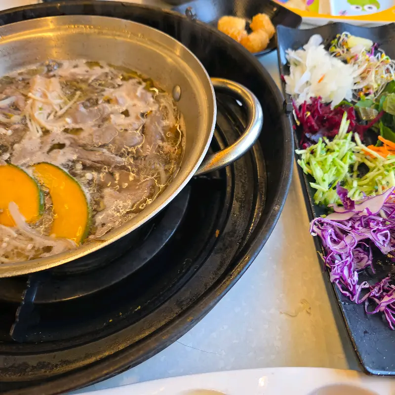 샤브샤브 육수에 신선한 야채와 고기를 넣어 끓이는 모습