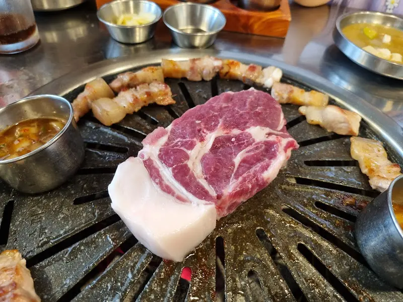 불판 위에 올려진 흑돼지 목살과 오겹살