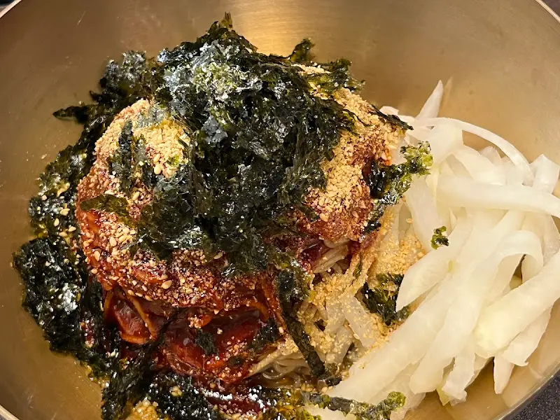 매콤달콤한 양념에 비벼진 메밀 막국수 위에 김 가루와 깨가 듬뿍 뿌려진 메밀 비빔 막국수