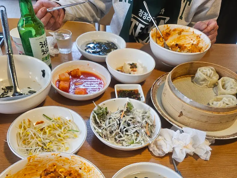 다양한 밑반찬과 산낙지 볶음덮밥, 연포탕이 차려진 테이블