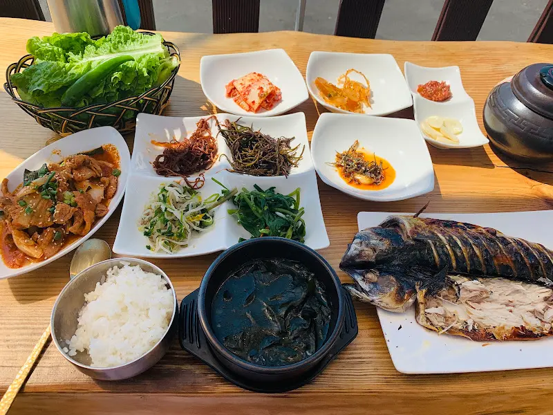 다양한 반찬과 흑미밥, 청국장이 놓인 테이블