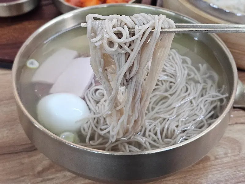 젓가락으로 들어올린 메밀면