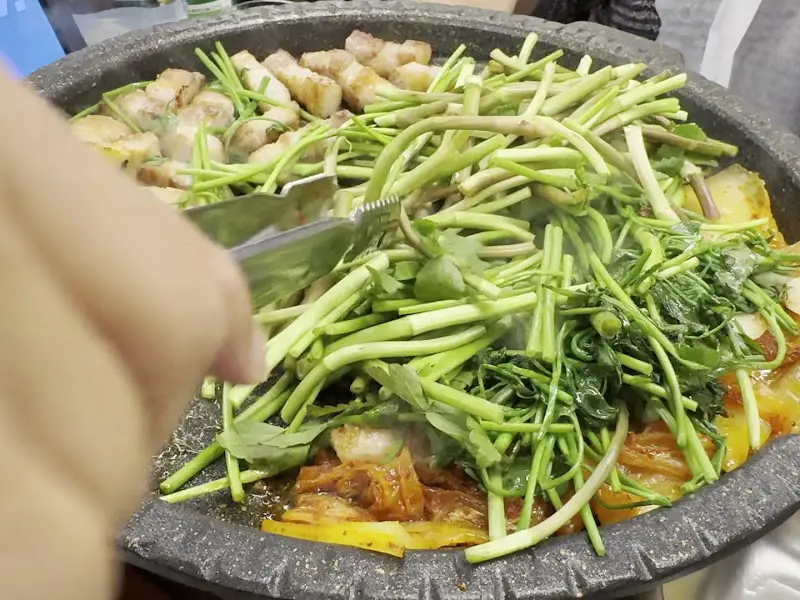 삼겹살과 미나리가 함께 구워지는 모습