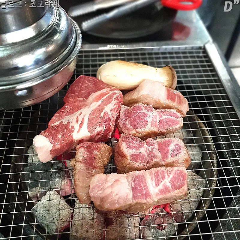 숯불 위에 올려진 신선한 목살과 버섯