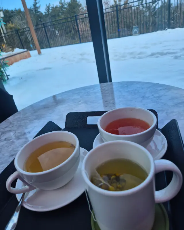 눈 내리는 풍경을 바라보며 즐기는 따뜻한 차 한 잔