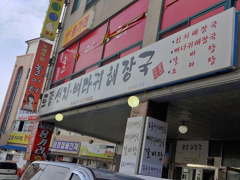 붉은색 어닝과 큰 글씨 간판이 인상적인 가게 외관