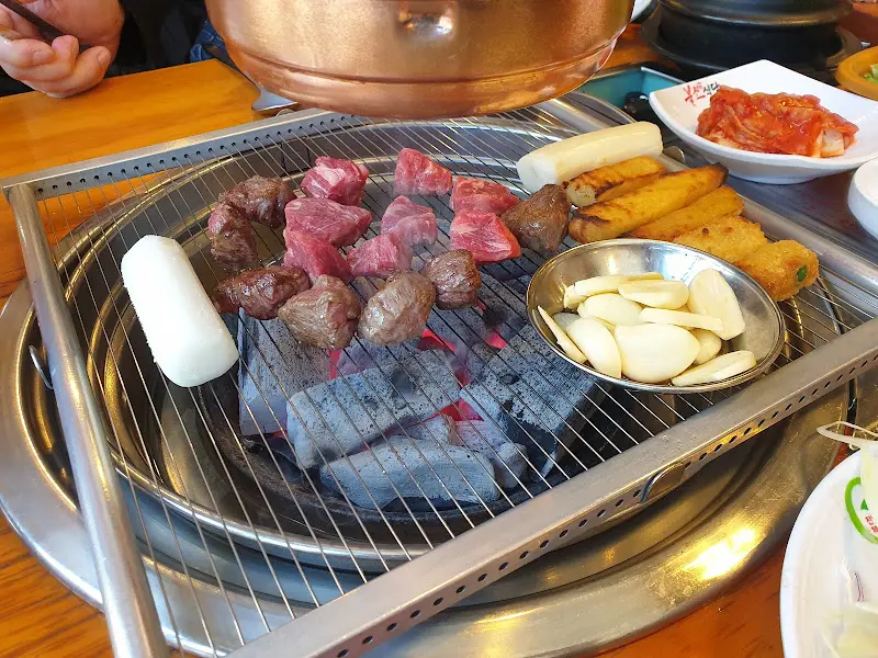 숯불 위에 구워지고 있는 소갈비살과 마늘