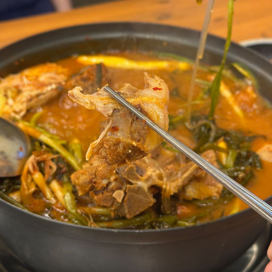 뼈에 붙은 살코기를 젓가락으로 집어 올리는 모습