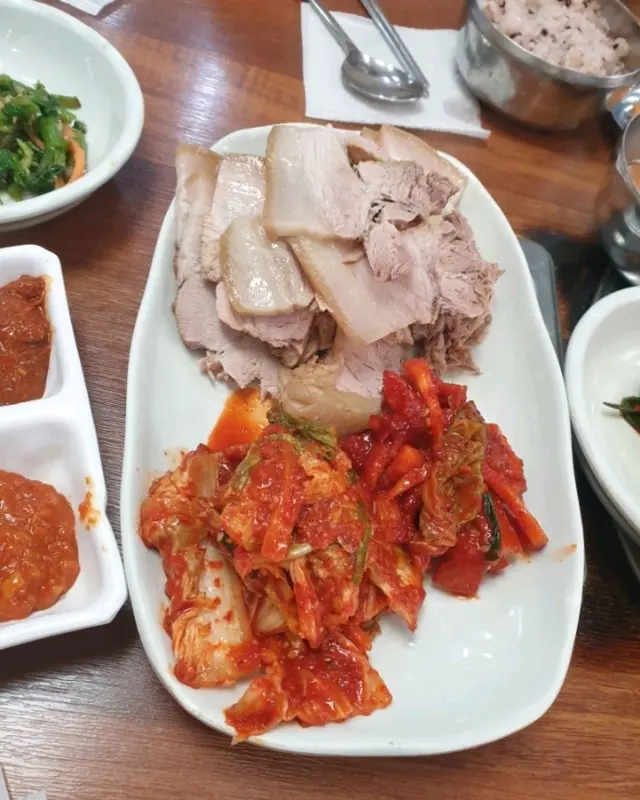 윤기가 흐르는 수육과 먹음직스러운 김치의 모습