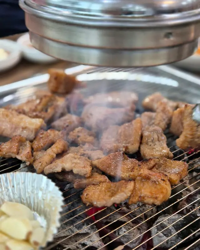 숯불 위에서 노릇노릇하게 익어가는 돼지갈비