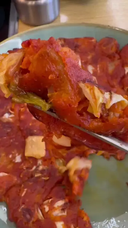 젓가락으로 집어올린 김치전