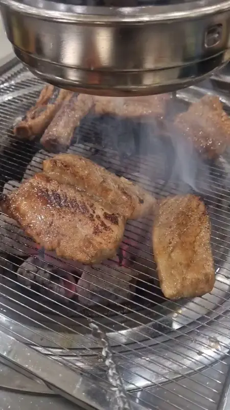 숯불 위에서 구워지는 윤슬갈비의 돼지갈비