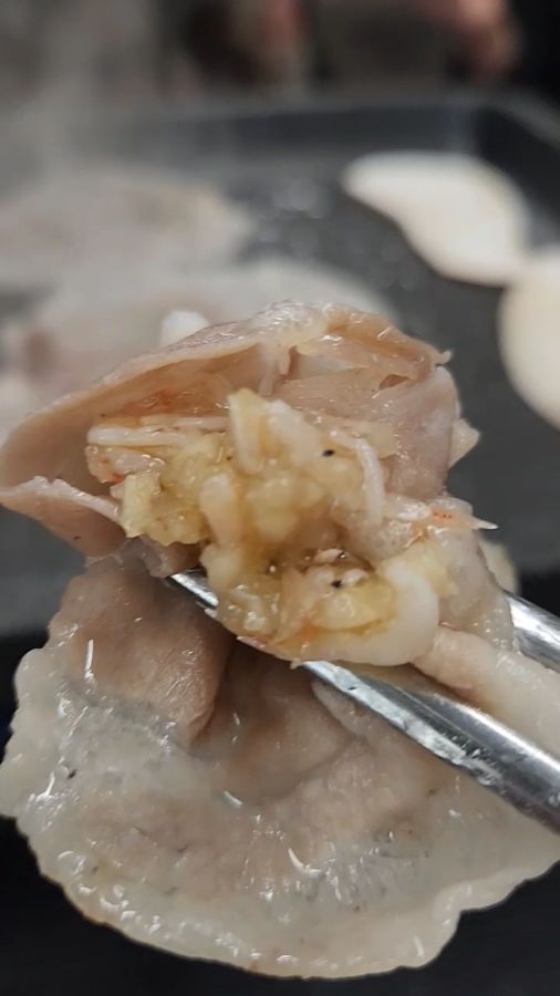 잘 익은 삼겹살을 젓가락으로 집어 올리는 모습