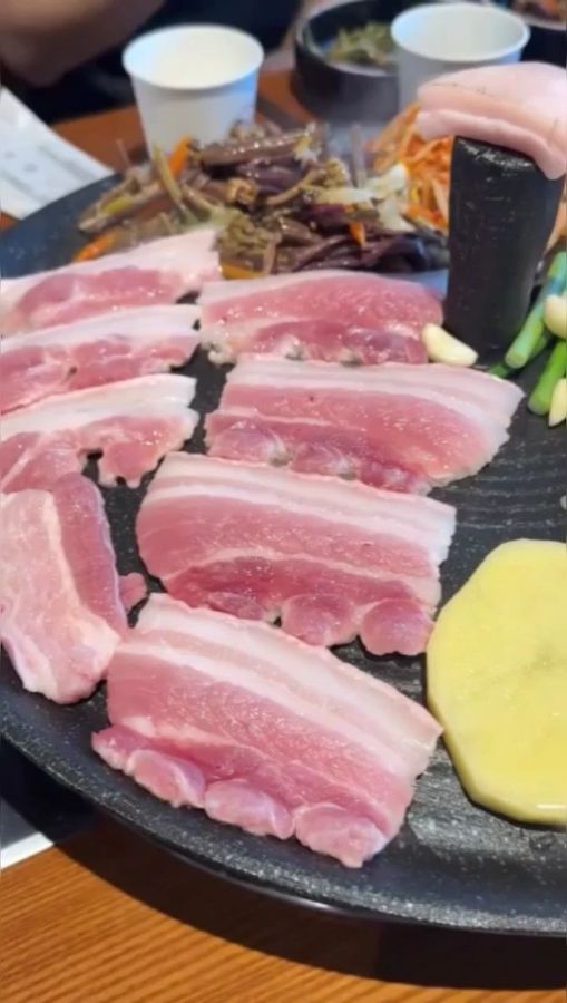 솥뚜껑 불판 위에 올려진 약돌 생삼겹살