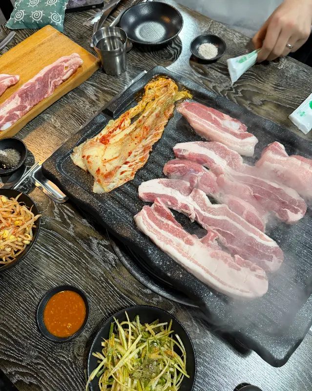 불판 위의 삼겹살과 김치