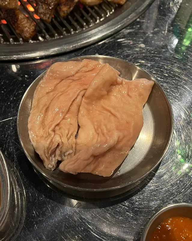 접시에 담겨 있는 뽀얀 돼지 껍데기의 모습