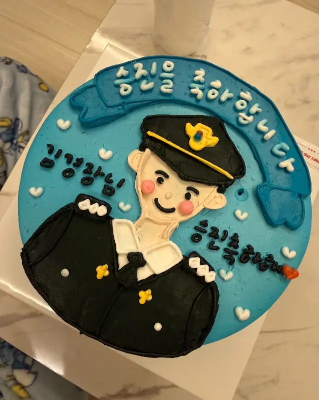 제복을 입은 캐릭터가 장식된 승진 축하 케이크