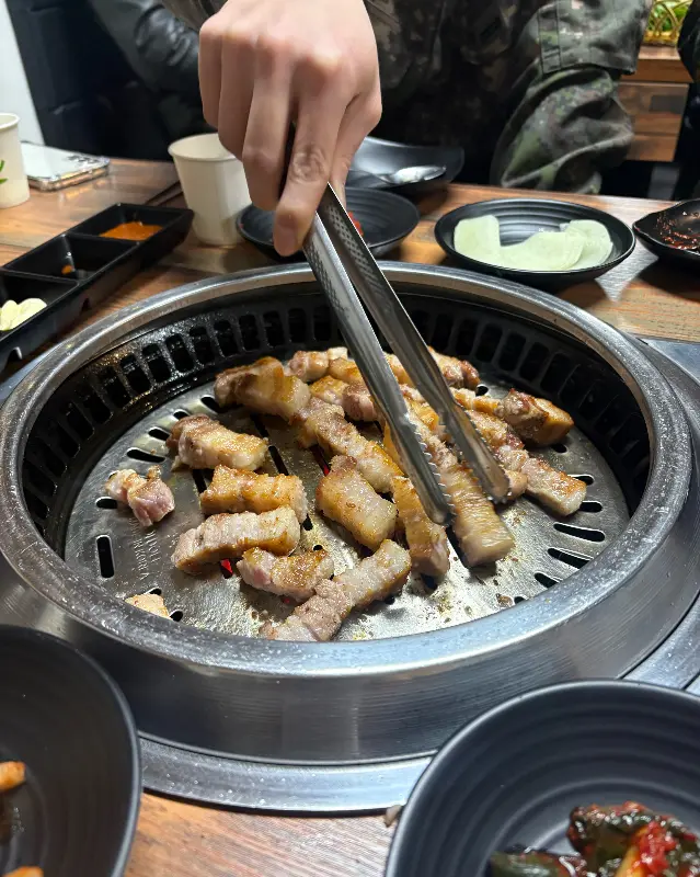 고기를 굽는 사람의 손과 숯불의 모습