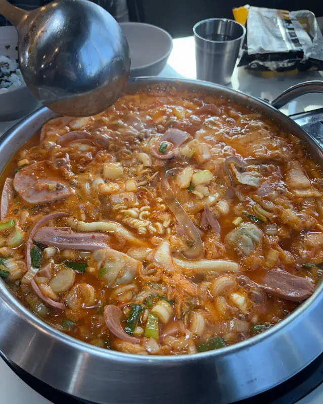국자로 부대찌개를 푸는 모습