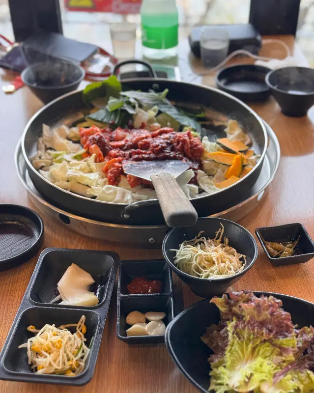 닭갈비와 푸짐한 밑반찬이 테이블 위에 놓여 있는 모습