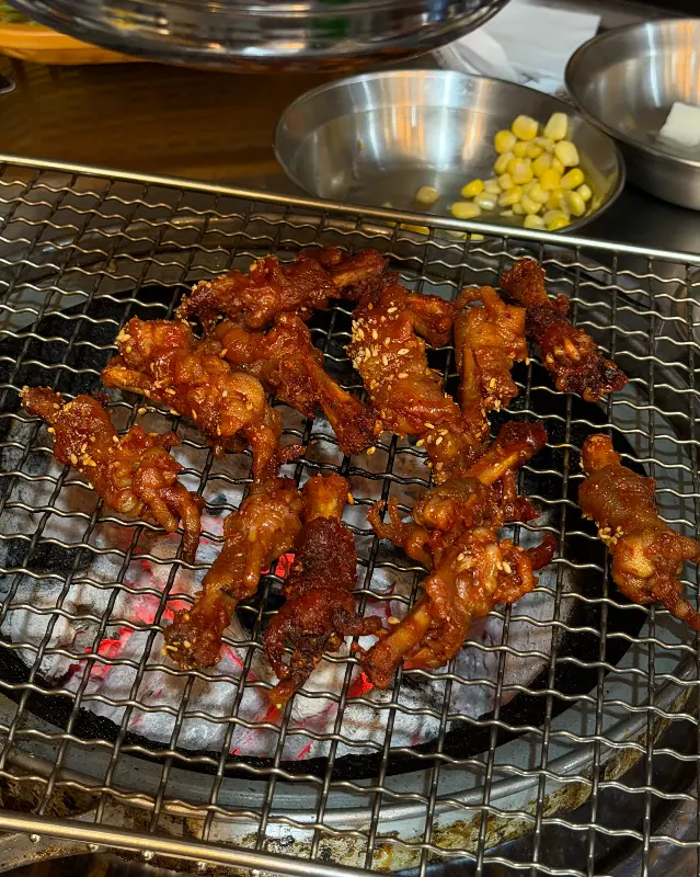 숯불 위에서 구워지는 매콤한 닭발