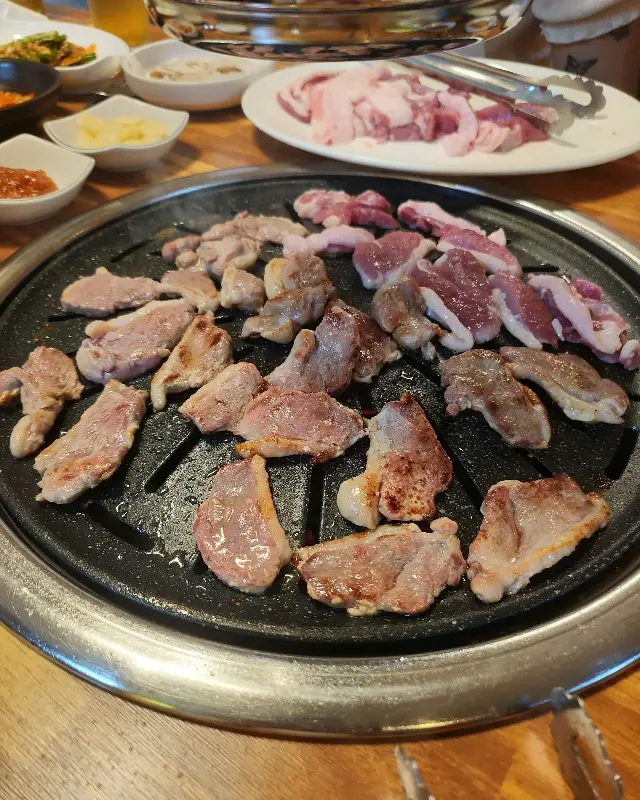 오리고기가 불판 위에서 맛있게 구워지고 있는 모습