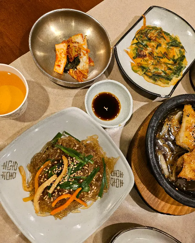 맛깔스러운 잡채와 김치전의 클로즈업 샷