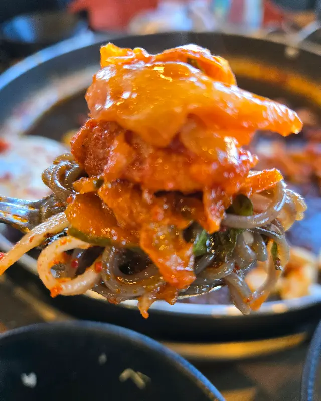 젓가락으로 닭갈비를 집어 올린 모습