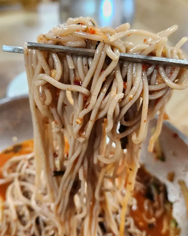 젓가락으로 집어 올린 막국수 면발