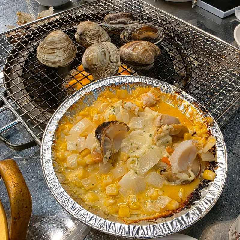 불판 위에서 조개와 해산물이 구워지고 있는 모습