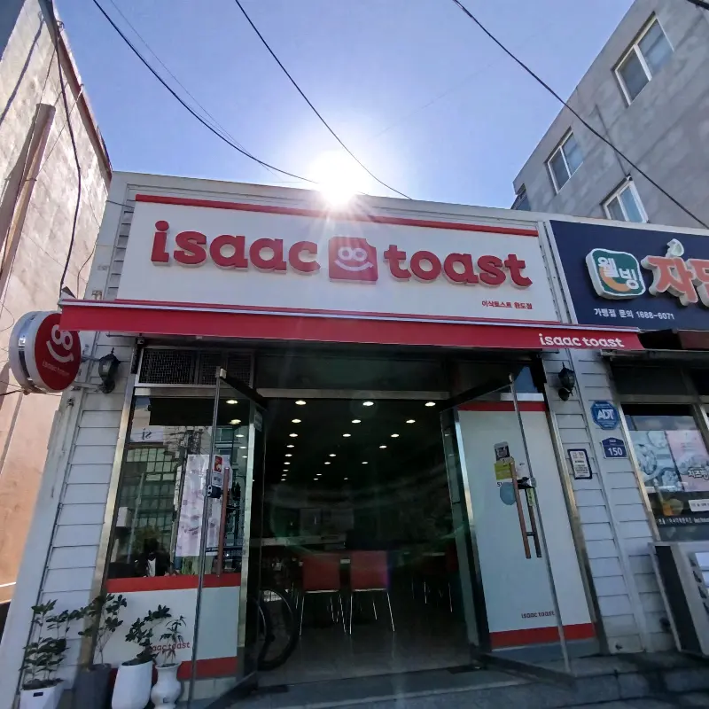환한 햇살 아래 빛나는 이삭토스트 완도점 간판